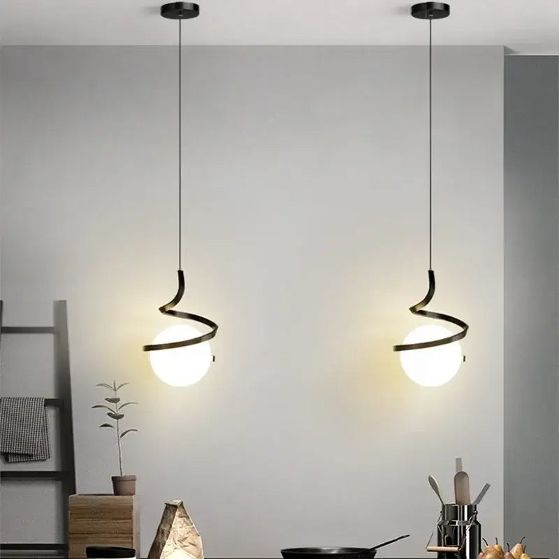 Two sleek black spiral cord pendant lights with frosted glass globes ideal for kitchen use under square meters