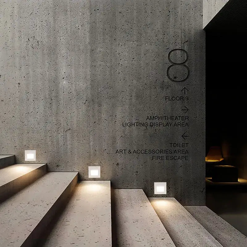 Concrete wall with engraved directional signage featuring black square and circular ip65 waterproof embedded step lights outdoor decorbites 3w ip65