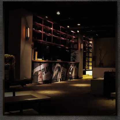Dark wooden wine rack with multiple shelves and decorbites black vintage industrial wall sconce with Edison bulb above