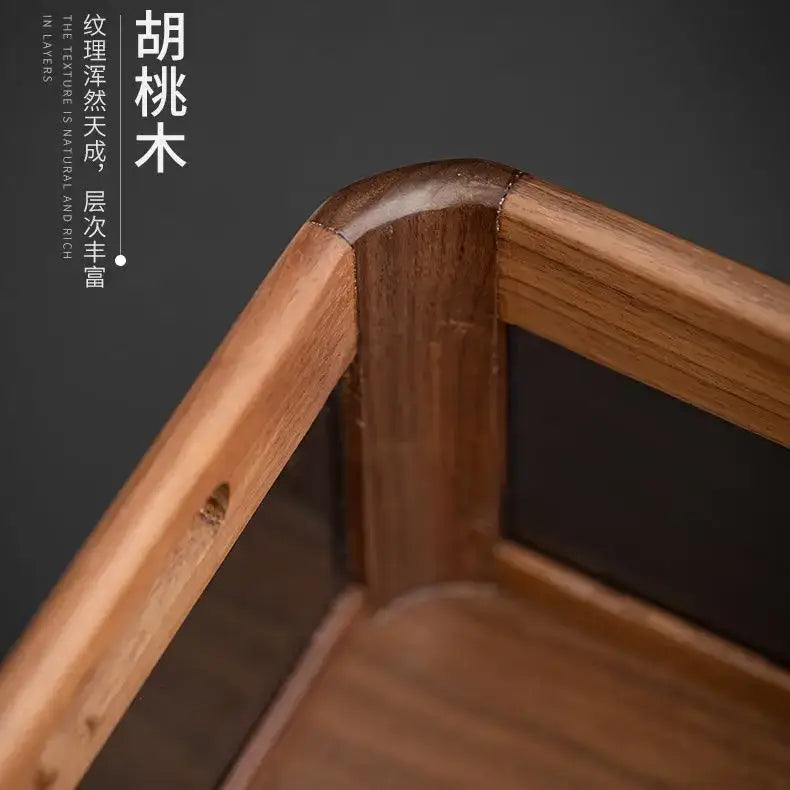A corner of a black walnut wood desktop organizer made from natural huali wood with rich grain and warm brown tones