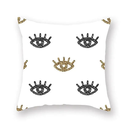 White throw pillow with black and gold glittery eye motifs featuring a geometric star stripe print for bedroom decor