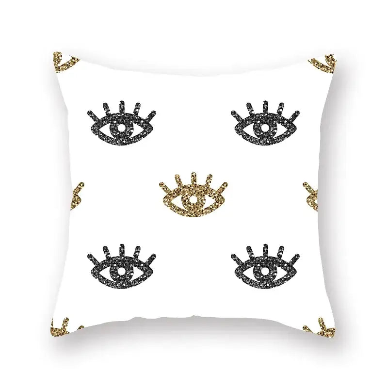 White throw pillow with black and gold glittery eye motifs featuring a geometric star stripe print for bedroom decor