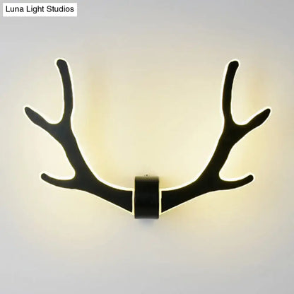 Black wooden antler wall lamp with illuminated edges providing warm led lighting for corridor use