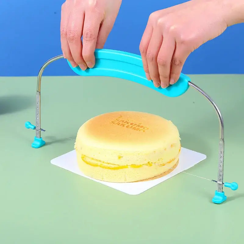 Blue adjustable stainless steel cake slicer with curved frame and clamps baking tool by decorbites