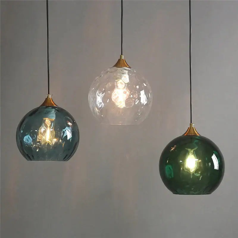 Three spherical glass ball pendant lights with textured teal clear and emerald green glass and brass-toned tops for decorbites glass ball led chandelier