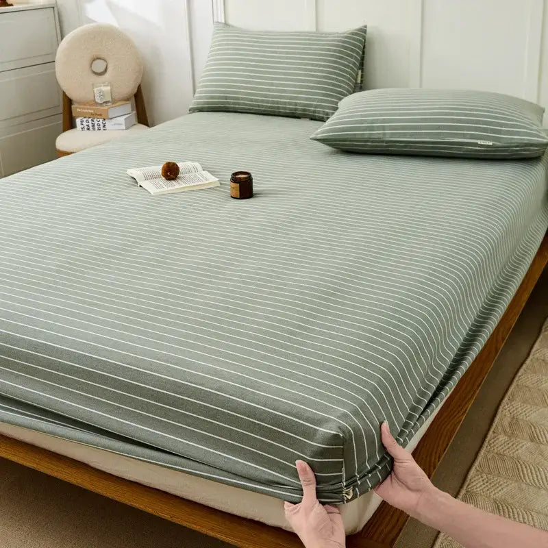 A soft sage green fitted sheet with delicate white stripes made from decorbites coarse cotton queen fabric