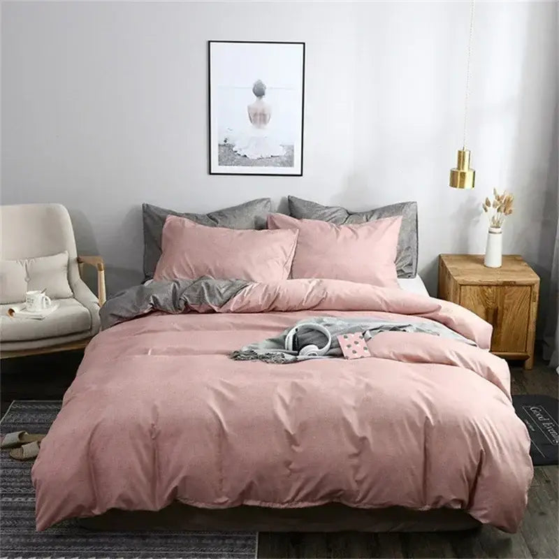 Pink duvet cover set with matching pillowcases and gray accent throw blanket complementing blue and gray bedding
