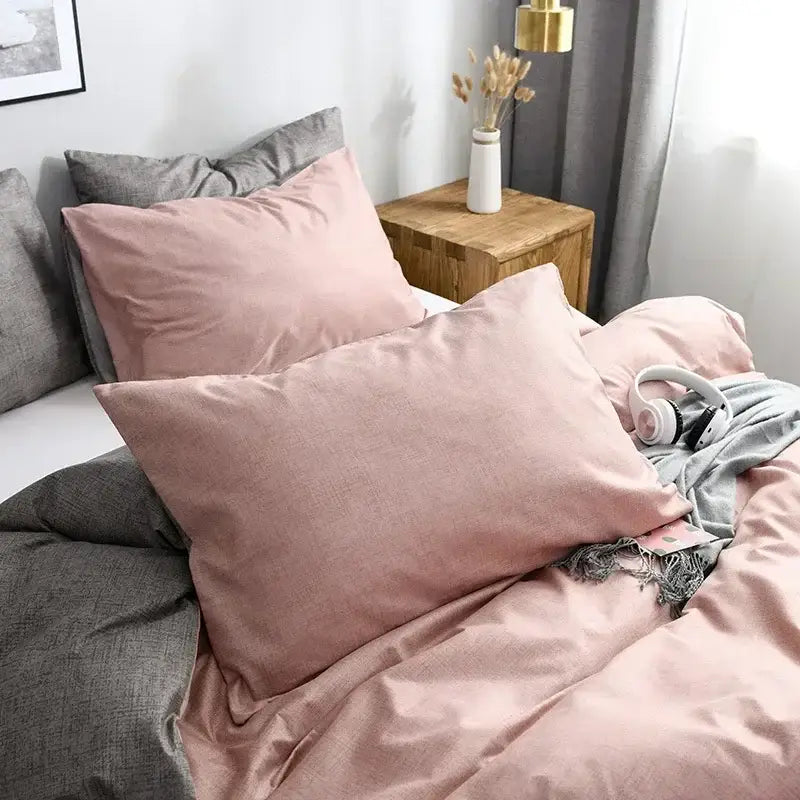 Soft pink linen pillowcases with subtle texture paired with blue and gray grain pattern duvet cover set bedding