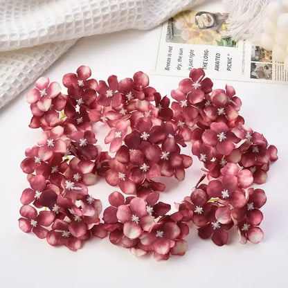 A cluster of artificial burgundy and white decorbites hydrangea flowers with delicate layered petals for wedding decor