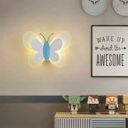 Blue butterfly girl cartoon wall light with translucent white wings and glowing yellow illumination for children room