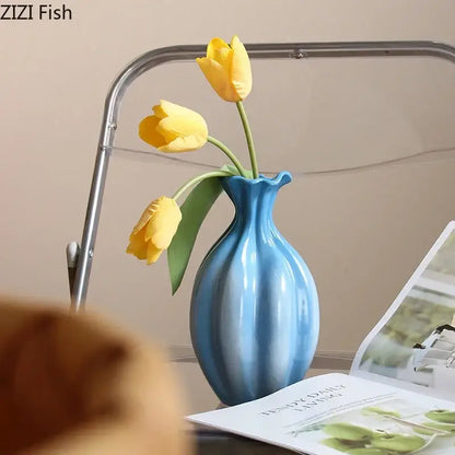 Glossy blue ceramic flower bud vase with fluted neck holding yellow tulips for decorbites blue ceramic decor
