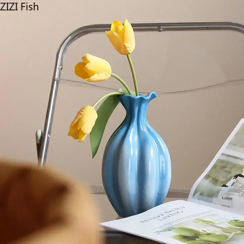 Glossy blue ceramic flower bud vase with fluted neck holding yellow tulips for decorbites blue ceramic decor