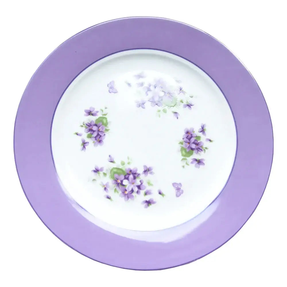 A delicate white porcelain plate with a lavender rim and hand-painted violets from the blue dream tea set