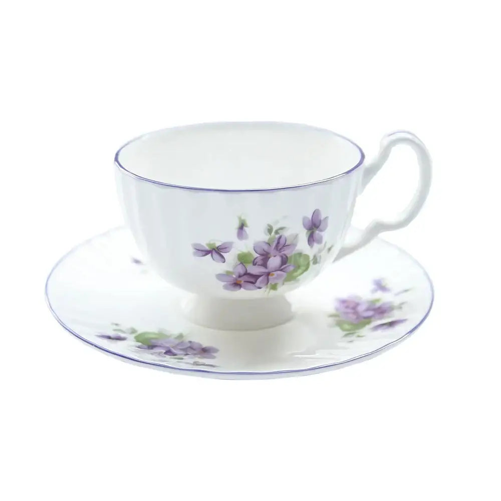 White porcelain tea set with delicate purple violet flowers green leaves and fine blue rim from the blue dream tea set