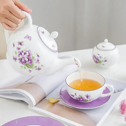White porcelain tea set teapot with purple violet blossoms and green leaves from the blue dream tea set