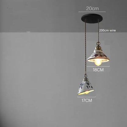 Two blue floral ceramic led pendant lamps with black patterns on white ceramic, suspended by dark chains for dining room lighting