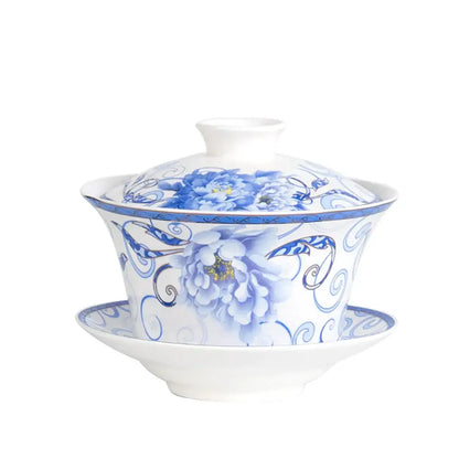 A white porcelain tea cup set with blue floral patterns including peonies on a teapot and matching saucer