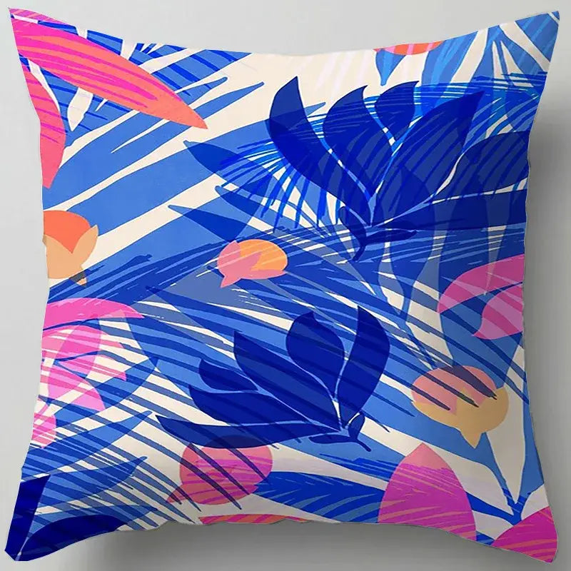 Vibrant tropical decorbites blue flower leaves pattern cushion cover with bold blue pink and orange leaf designs on white background