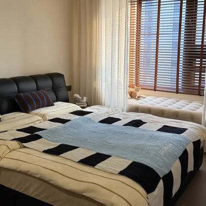 Black tufted leather headboard with striped pillow and blue green black momochi flannel sofa blanket decorbites cozy