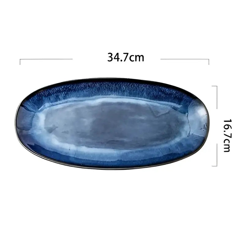 An oval ceramic sushi plate with blue kiln glazed gradient from navy to light blue featuring a glossy finish