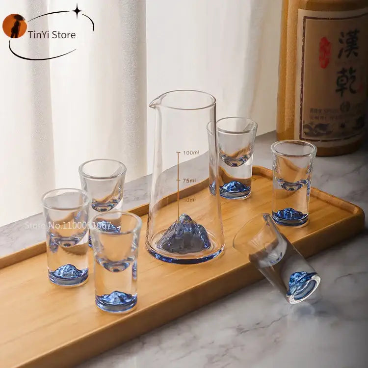 Clear glass decorbites blue sake glass set with blue mountain designs and matching sake glass ice measuring pitcher on wood tray