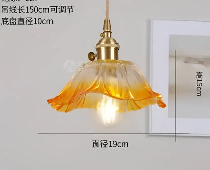 A warm-toned amber glass pendant light with brass fixture and petal design by decorbites pendant lights for bedroom decor