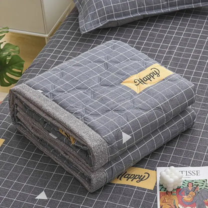 Gray quilted blanket with subtle grid pattern and yellow happy patch featured in decorbites daisy print quilt collection