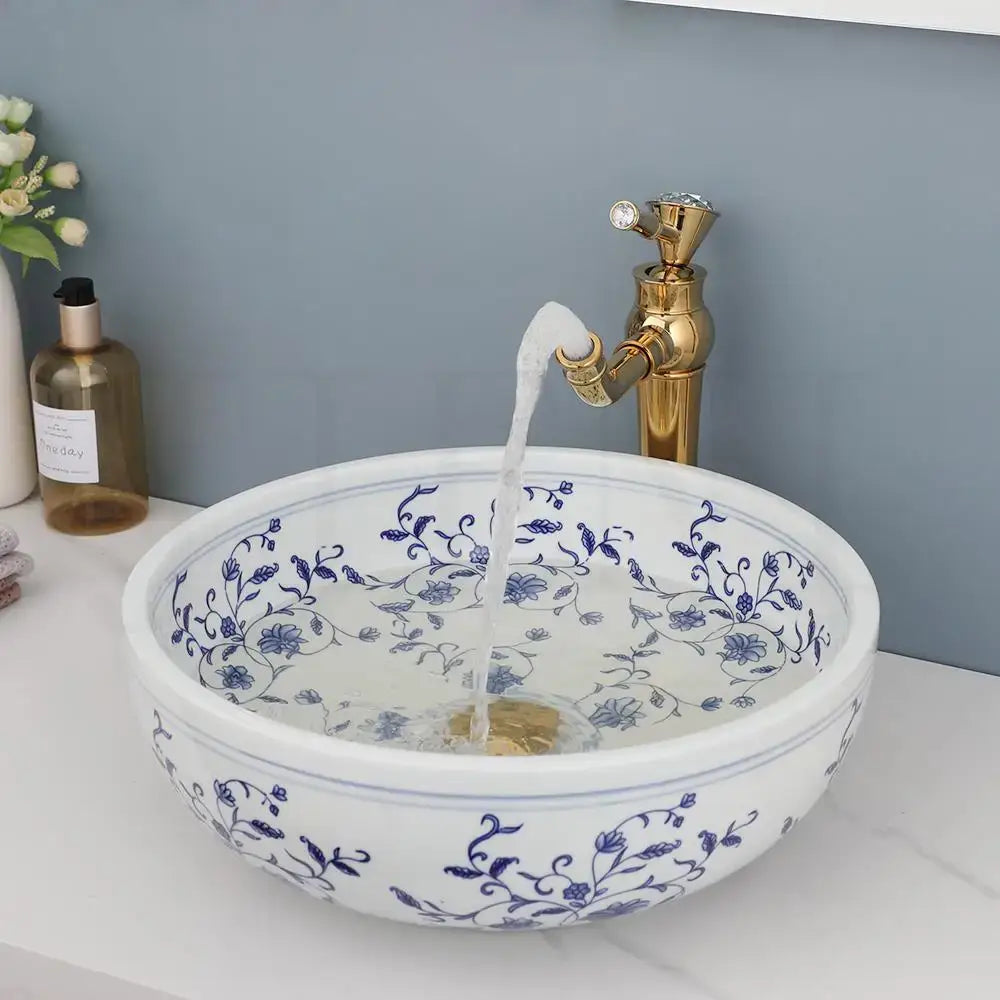 White porcelain basin set featuring a pop drain and intricate blue floral patterns for bathroom use