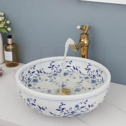 White porcelain basin set featuring a pop drain and intricate blue floral patterns for bathroom use
