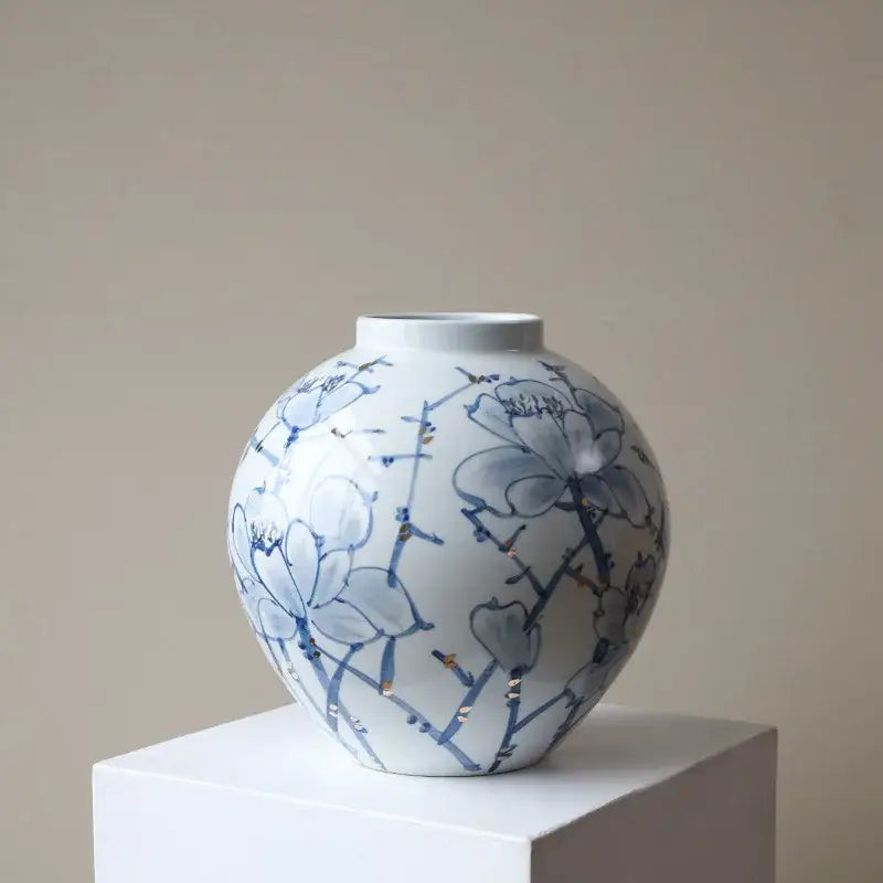 White porcelain ceramic vase with blue floral patterns and gold accents for decorbites blue living room decor