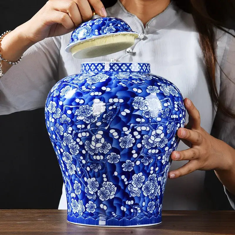 A glossy blue and white porcelain pot sealed storage ginger jar with intricate floral patterns and matching lid lined with yellow fabric