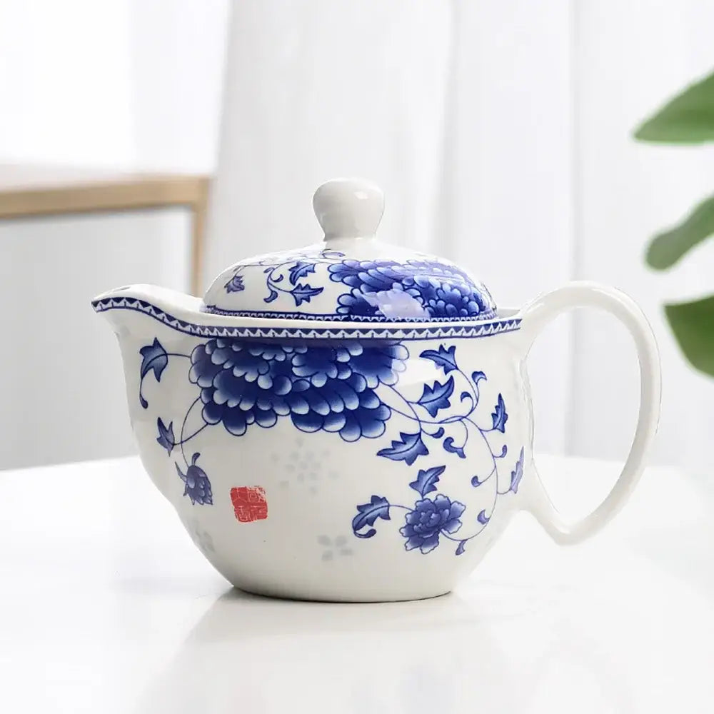 Blue and white porcelain tea pot set featuring a white porcelain tea pot with intricate blue floral patterns and red seal mark