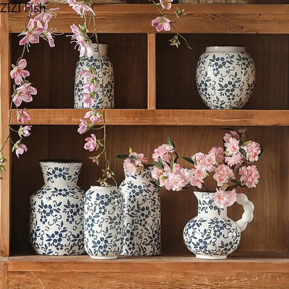 A white porcelain vase with blue white porcelain floral pattern and curved handle filled with pink blossoms for decorbites blue white hydroponic living room decor