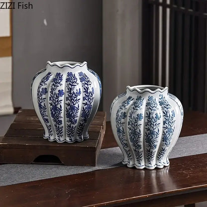 Two elegant white porcelain vases with blue floral patterns and artificial flowers for desk decor