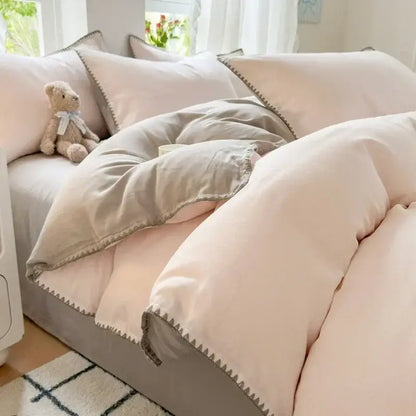 Soft blush and gray cotton bedding set with subtle zigzag stitch trim for a stylish bedroom look