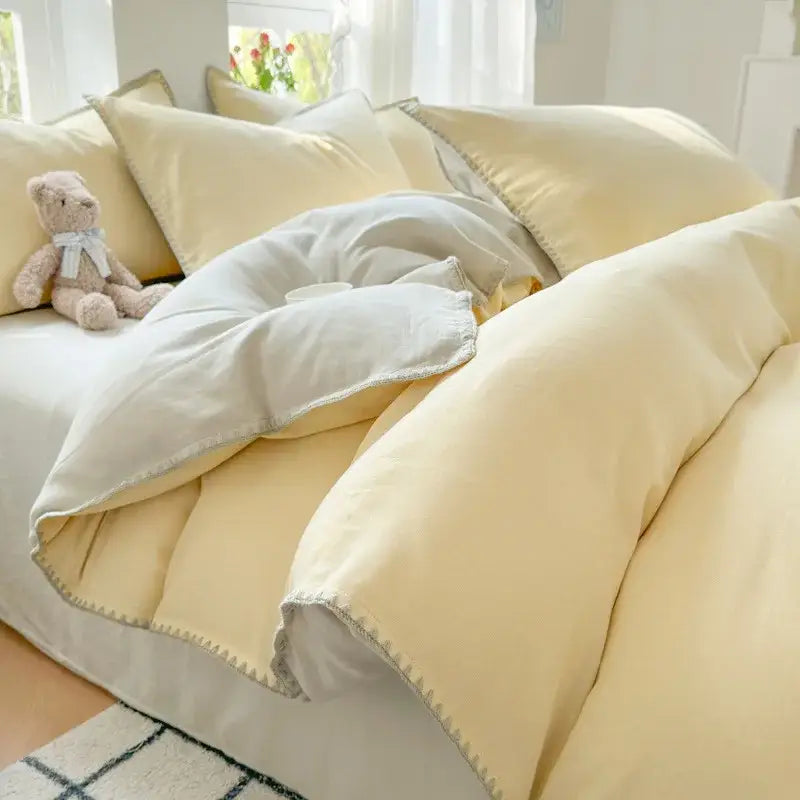 Soft pale yellow quilted duvet with gray cotton edge embroidery and matching pillows in decorbites bedding set