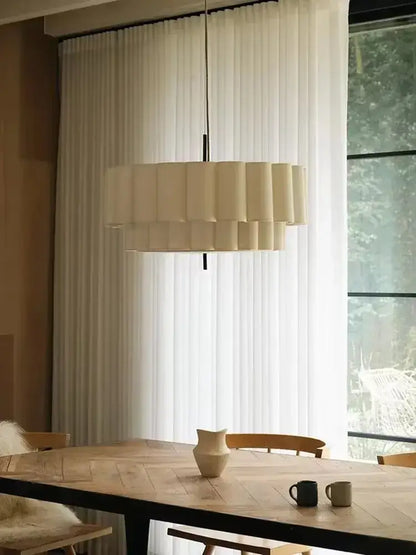 Cream-colored tiered paper bohemia fabric chandelier pendant light by decorbites hanging above dining table