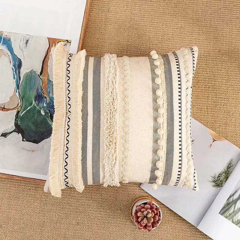Beige and gray striped cushion cover with textured fringe pom-poms and woven details for home decor by decorbites bohemian beige