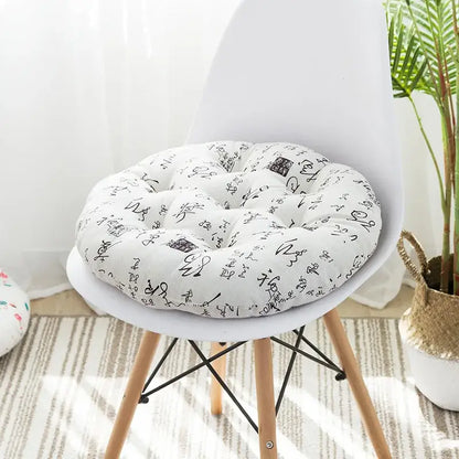 White circular meditation cushion pouf with black calligraphic script pattern tufted soft fabric for living room use