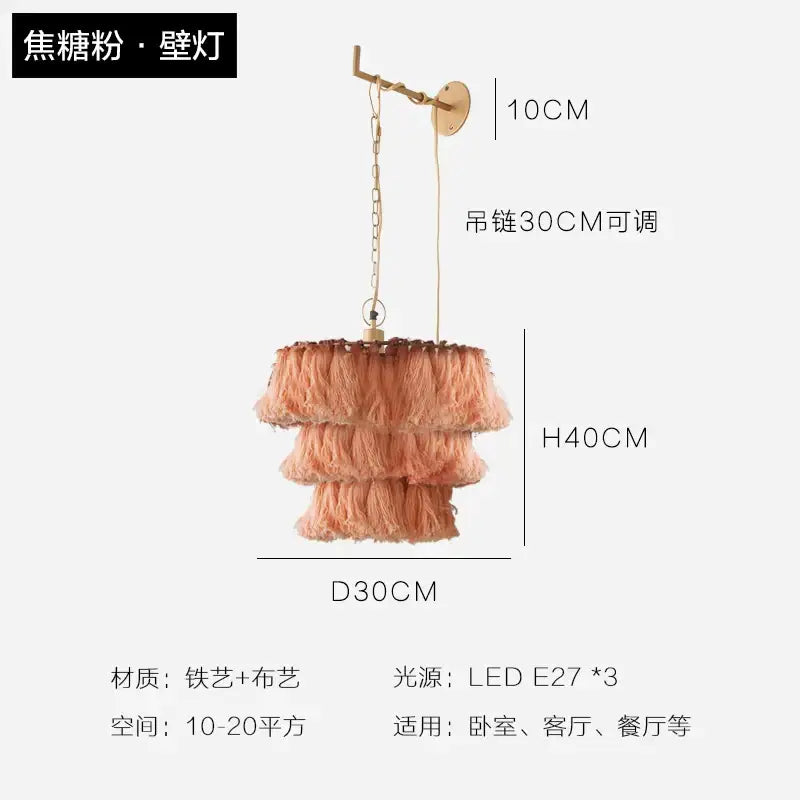 A tiered peach-colored tassel light with a brass-finished metal frame and chain suspension light by decorbites bohemian chandelier