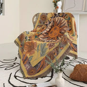 A vibrant yellow decorbites bohemian camping blanket featuring sun and floral patterns with fringed edges for living room decor