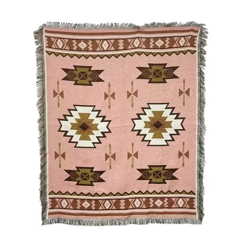 A soft pink woven throw blanket with brown cream and olive green geometric tribal patterns and fringed edges decorbites bohemian classic design