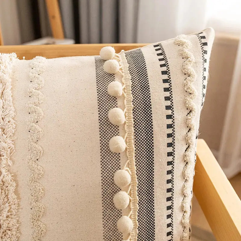 Cream-colored bohemian cotton cushion cover with black and white stripes and fluffy pom-poms for living room decorbites decor