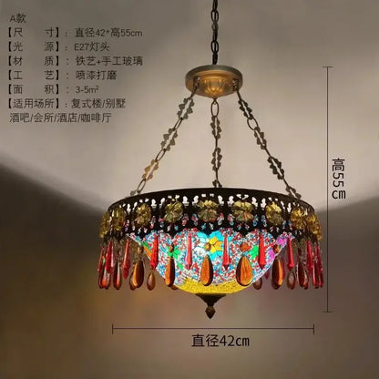A vibrant bohemian exotic stained glass pendant light with a black wrought iron frame and gold red beads for dining decor