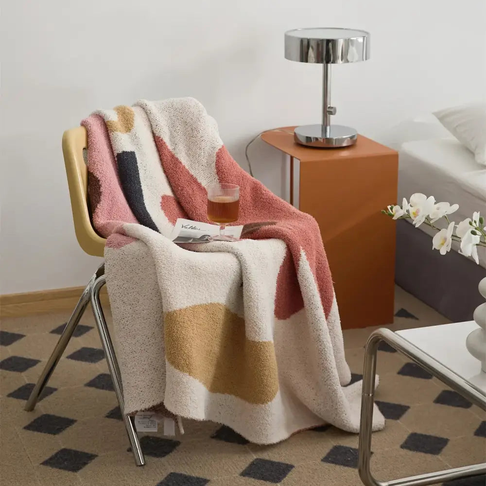 Cozy decorbites bohemian flower knitted throw blanket in cream with abstract geometric patterns draped over chair