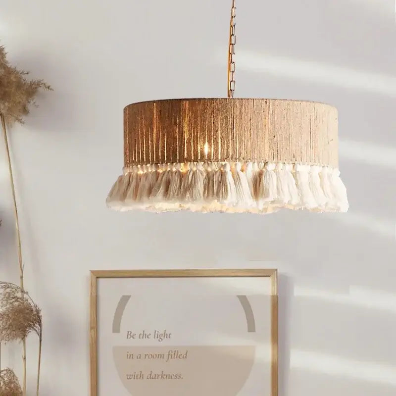 A cylindrical pendant light with textured gold finish and cream tassels from decorbites bohemian hemp rope 3 pack