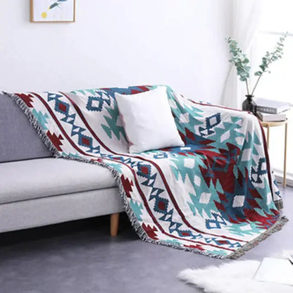 Cozy bohemian multicolored geometric tassel sofa cover with teal red and white pattern and fringed edges by decorbites