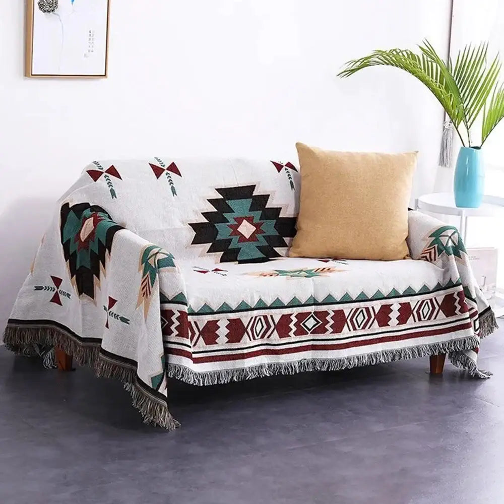 White woven bohemian multicolored geometric tassel sofa cover with black teal maroon patterns and fringed edges by decorbites
