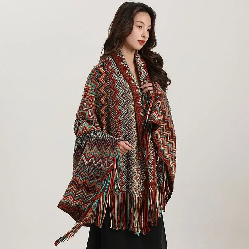 A vibrant bohemian wavy fringe shawl knit with zigzag patterns in red teal and brown for living room use