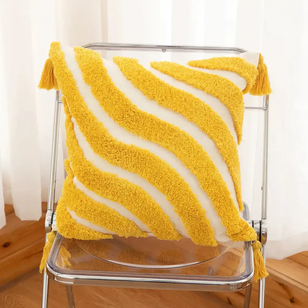 A cozy mustard-yellow and white striped bohemian tufted tassel pillow with fluffy corner tassels for living room decor